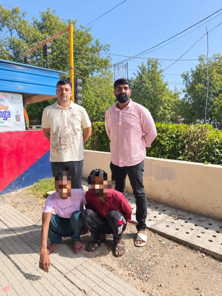 पुलिसकर्मियों के साथ पकड़े गए दो व्यक्ति, जिनके चेहरे उपलब्ध कराई गई तस्वीर में धुंधले हैं