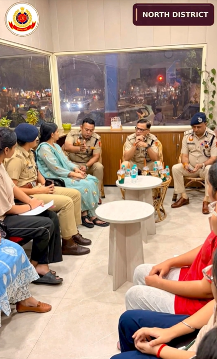 डीयू नॉर्थ कैंपस के पिंक बूथ पर पुलिस अधिकारियों के साथ बैठकर बातचीत करतीं छात्राएँ