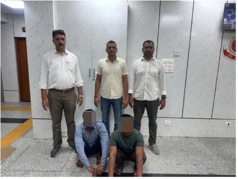 महिंद्रा पार्क में सेंधमारी के दो मामलों में दो गिरफ्तार; सोना और ₹16,000 बरामद पुलिस टीम के सामने बैठे चेहरे ढके दो गिरफ्तार व्यक्ति