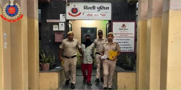 हौज काजी थाने के बाहर गिरफ्तार आरोपी के साथ पुलिसकर्मी