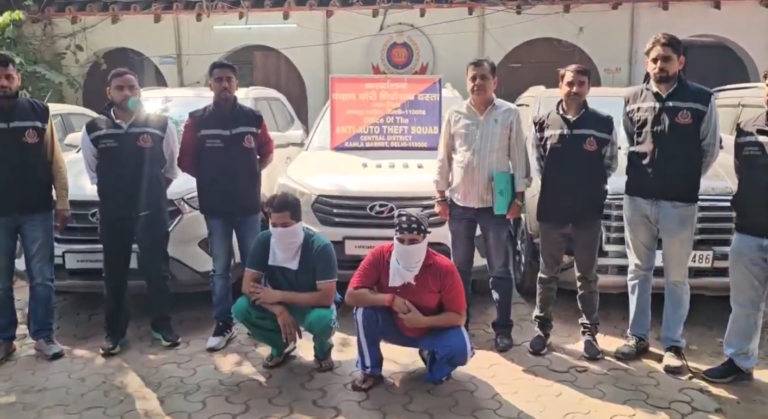 मध्य जिला AATS कार्यालय के बाहर कारों के पास पुलिसकर्मी और चेहरा ढके दो बैठे व्यक्ति