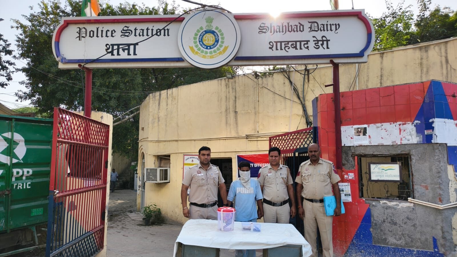 शाहबाद डेरी में हथियार के साथ गिरफ्तारी से लूट केस का सुराग; नकदी और पहचान दस्तावेज बरामद शाहबाद डेरी थाने के बाहर बरामद सामान और आरोपी के साथ पुलिस अधिकारी