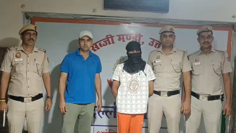 ब्रीफिंग कक्ष में पुलिसकर्मियों के साथ दो पुरुष; एक ने चेहरा ढका हुआ है।
