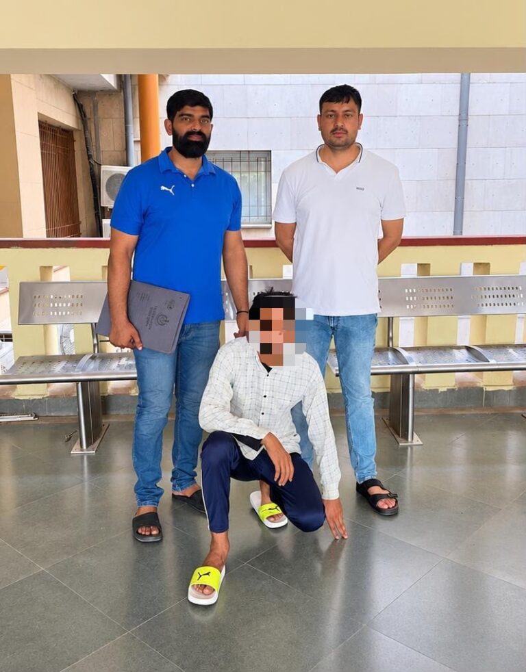 पुलिस के साथ उपलब्ध कराई गई तस्वीर में दो खड़े व्यक्ति और पिक्सेलेटेड चेहरे वाला एक बैठा व्यक्ति