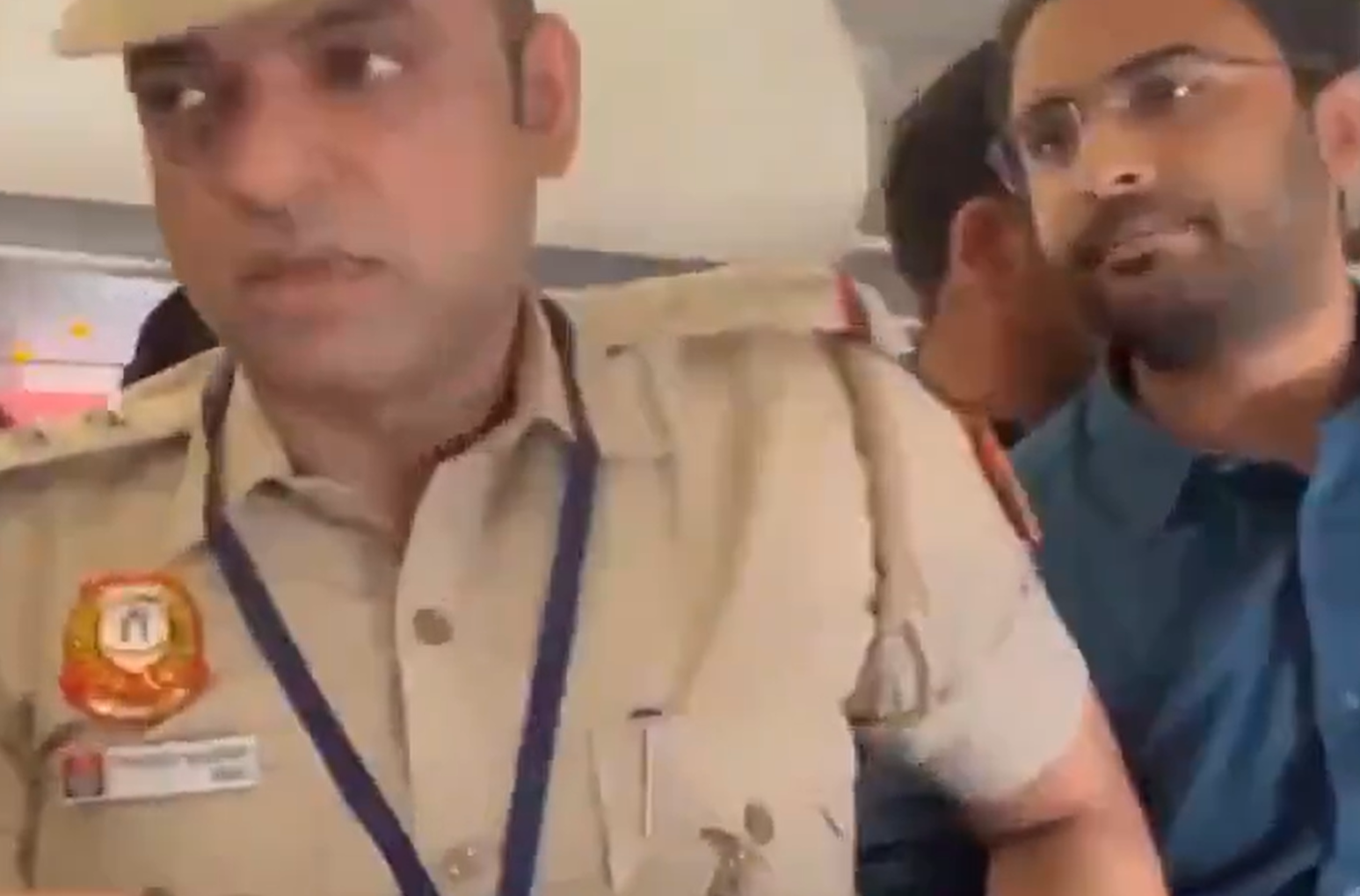 विमान में पुलिसकर्मी और चश्मा पहने व्यक्ति