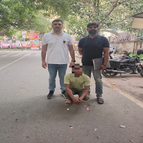 घोषित अपराधियों के खिलाफ कार्रवाई में पकड़े गए एक व्यक्ति के साथ पुलिसकर्मी। उपलब्ध कराई गई तस्वीर में चेहरा छिपा हुआ है