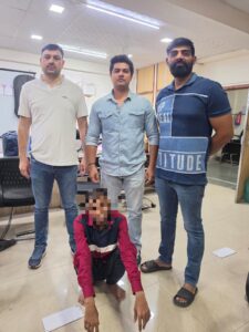 2017 के नरेला मामले में घोषित अपराधी गिरफ्तार: पुलिस धुंधले चेहरे वाला बैठा व्यक्ति और उसके पीछे खड़े तीन लोग।
